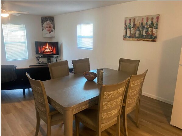 A dining area with a table, chairs, a television, and a fireplace. - Cozy 2-bedroom house in beautiful Melbourne with AC (Melbourne)