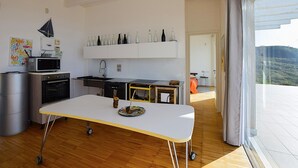 A modern kitchen with a white countertop, stainless steel appliances, and a view of the outdoors.