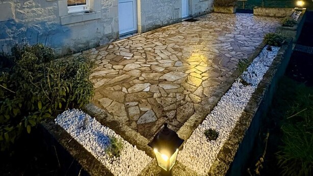 A stone building with a tiled entrance and a small garden area. - La Bergerie des vignes" country house shared with sheep. (Bourgueil)