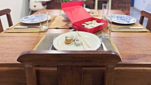 Ein Esstisch gedeckt mit Tellern, Stäbchen und einer Sushi-Box.