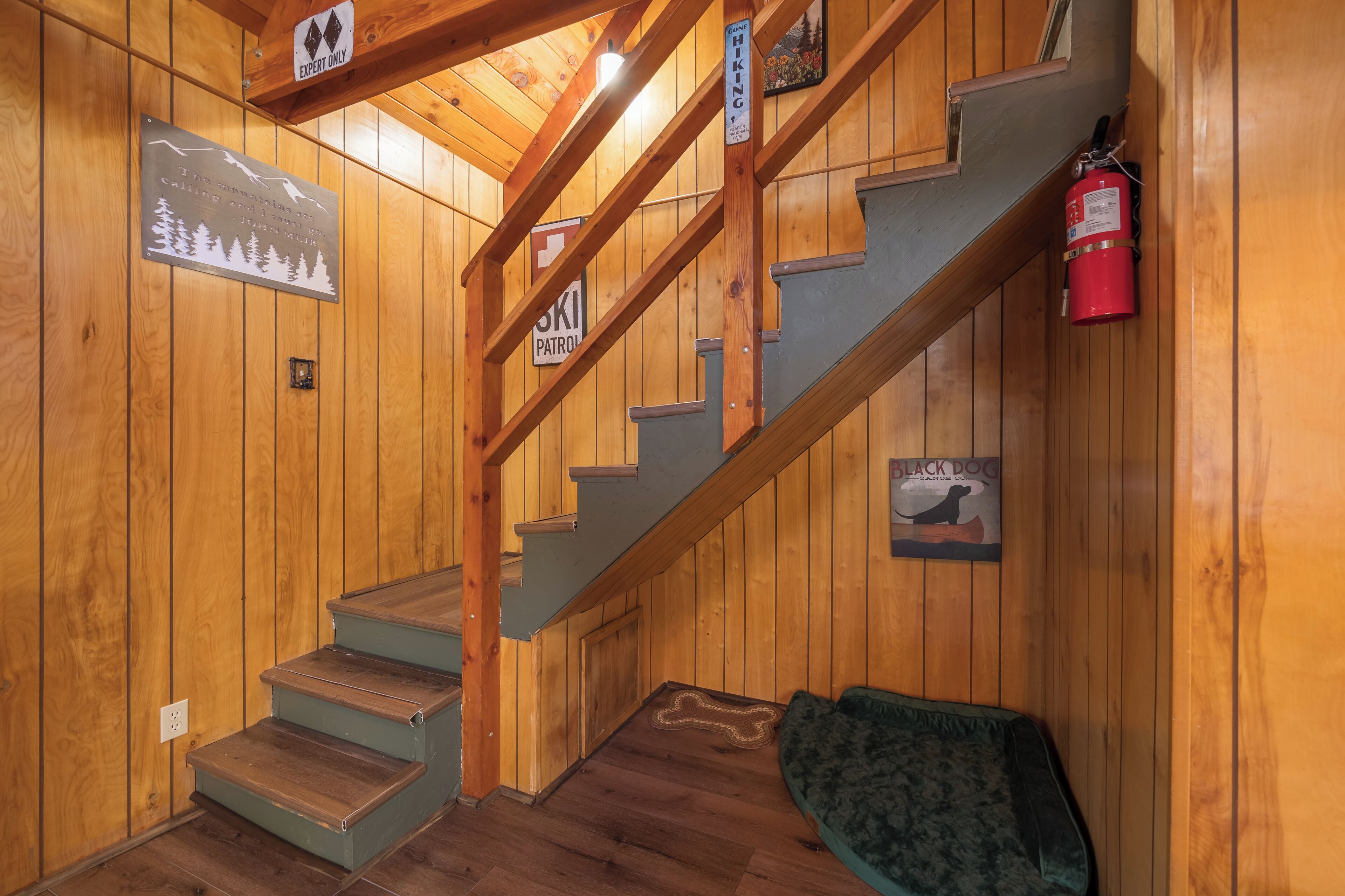 A wooden staircase with a sign for a ski patrol and a black dog mascot.
