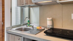 Una cocina moderna con un lavamanos de acero inoxidable, una estufa empotrada y armarios de madera.