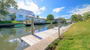A waterfront property with a dock, a house, and a boat. - Clover Vacation Homes: Snead Island: Luxury 4 BR, Heated Pool, Beaches (Palmetto)
