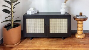A modern living room with a black entertainment center, a large potted plant, and a small wooden side table. - Baranda OCHO By Smart W (Mexico City)