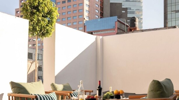 A rooftop terrace with a dining table, chairs, and a potted plant. - Baranda OCHO By Smart W (Mexico City)