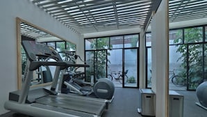 Une salle de sport équipée de tapis de course, d’un vélo d’appartement et d’un appareil d’aviron.