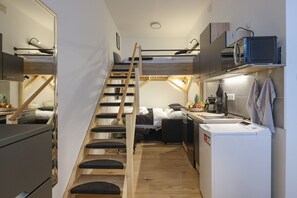 A compact kitchen with a built-in microwave, a sink, and a compact refrigerator.