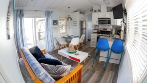 A compact living space with a kitchenette, dining area, and a sofa with a table.