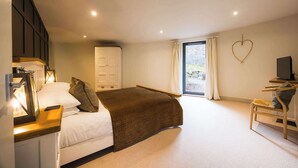 Ein Schlafzimmer mit Bett, Nachttisch, Lampe, Kleiderschrank und Schreibtisch mit Stuhl.