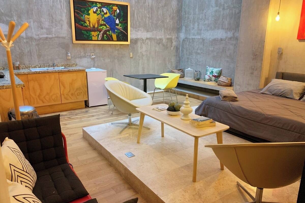 Een knus verblijf met een kitchenette, een bank, een eettafel en een bed.