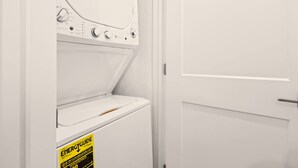 Une machine à laver blanche, dotée d’une étiquette ENERGYGUIDE, d’une porte et placée devant un mur blanc.
