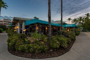 A restaurant with outdoor seating, palm trees, and a Caribbean-themed sign. - On the Beach | Pool + Hot Tub + Restaurant | Gated (St. Thomas)