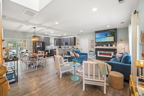 A spacious living area with a kitchen, dining table, and seating arrangements.