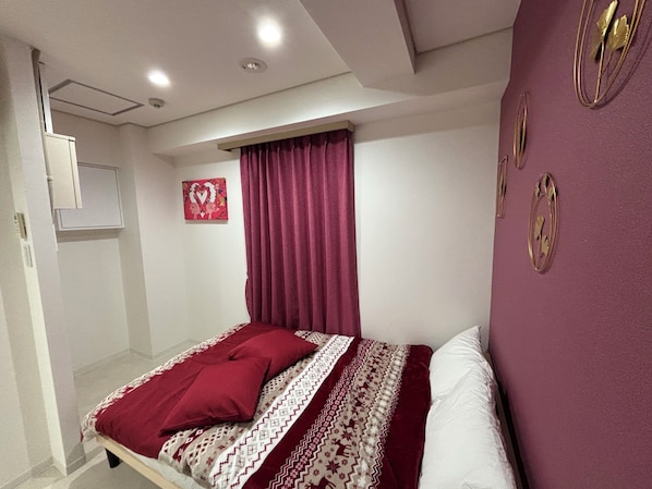 A bedroom with a bed, a window with curtains, a wall-mounted artwork, and a ceiling light. - Hotel Leap (Osaka)