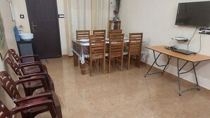 A living room with a dining table, chairs, a television, and a ceiling fan. - Blue Hills View - Serviced Villa in Attapadi,Kerala -rooms with mountain view (Attapadi, Palakkad)
