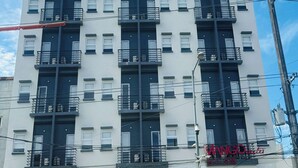 A multi-story building with a white facade and dark window frames. - Mango Suites Angeles (Angeles City)