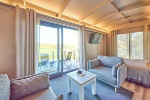 Een kamer met een bank, een klein tafeltje en een aan de muur bevestigde televisie.