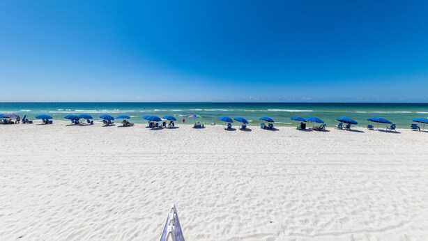 A beach with rows of blue umbrellas and beach chairs. - Bama Breeze | Little Lagoon w/ Fishing Dock | Dog Friendly | My Beach Getaways (Gulf Shores)