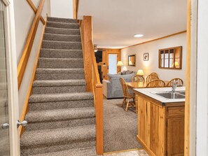 Eine Treppe führt zu einem Wohnbereich mit Sofa, Esstisch und Stühlen.