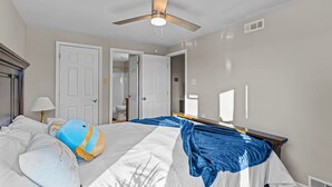 A hotel room with a bed, a ceiling fan, and a bathroom visible through an open door. - Safe, Quiet home with huge Fenced yard and parking (Maryland Heights)