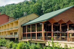 Ein Hotel mit Gründach, großen Fenstern, Außenplätzen und einem Balkon.