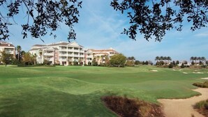 Un campo de golf con un club de campo al fondo.