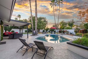 A swimming pool with lounge chairs and a covered patio area. - Saguaro Serenity | Stylish Home w Pool & Hot Tub (Scottsdale)