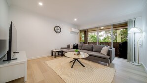 A modern living room with a sofa, coffee table, and TV. - Your Calm Corner in Lane Cove North (Lane Cove North)