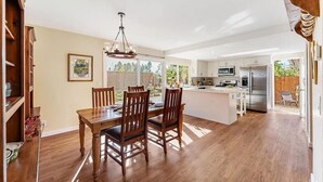 A spacious kitchen with a central island, wooden dining table, and chairs. - Quiet and Spacious 4BR Goleta Home with a Big Yard and Near Beaches & UCSB (Goleta)