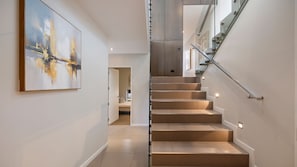 Eine moderne Treppe mit Glasgeländern und integrierter Beleuchtung.
