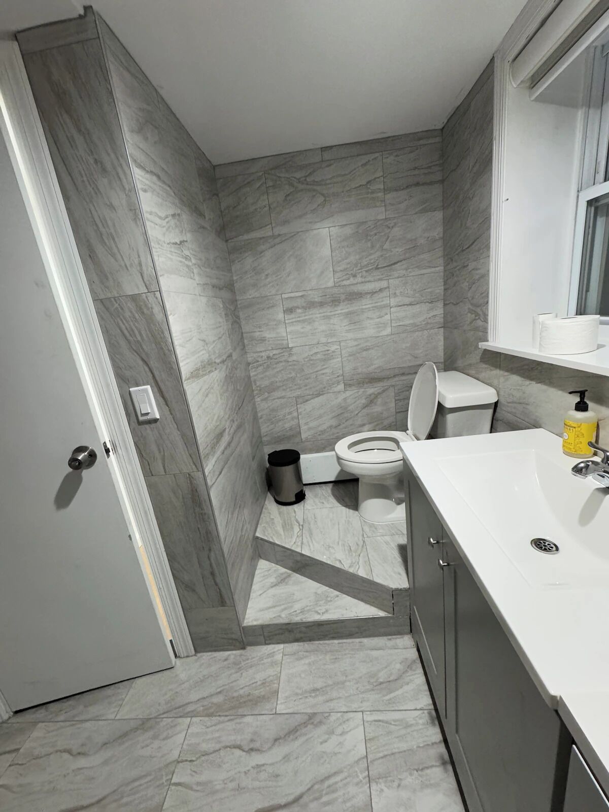 Une salle de bain avec des toilettes, un lavabo et un miroir.