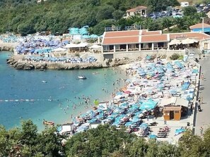 A crowded beach with numerous umbrellas and people enjoying the water. - Gemütliche Wohnung mit Meerblick vom Balkon aus by Interhome (Utjeha)