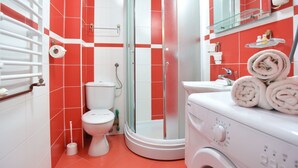 A bathroom with a shower, toilet, and washing machine. - Studio für 2 Personen by Interhome (Tivat)