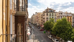 A street view with buildings, a crosswalk, and parked cars. - Hostal Venecia (Granada)
