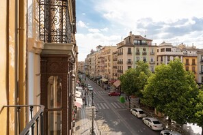 A street view with buildings, a crosswalk, and parked cars. - Hostal Venecia (Granada)