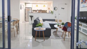 Een moderne woonkamer met een bank, salontafel en eethoek.
