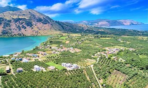 A coastal town with residential buildings, vineyards, and a mountainous backdrop. - Villa Galini Sifis (Apokoronas)