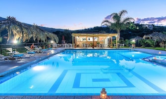 Una piscina con sillones de descanso y una zona de bar.