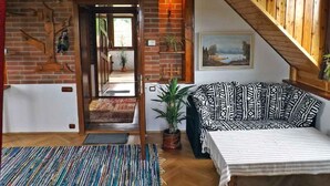 Un salon chaleureux avec un canapé, un tapis et un escalier.