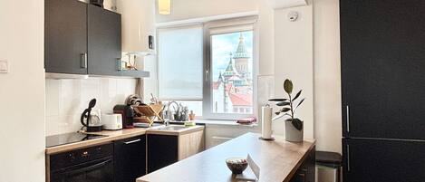 Een koelkast, een oven, een vaatwasser, kookgerei, borden en bestek