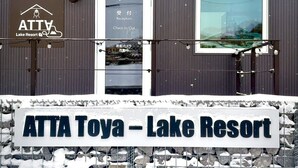 A sign for ATTA Toya - Lake Resort with a reception area and a window with a view. - ATTA Toya  - Lake Resort (Sobetsu)