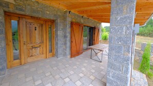Un patio cubierto con paredes de piedra y puertas de madera.