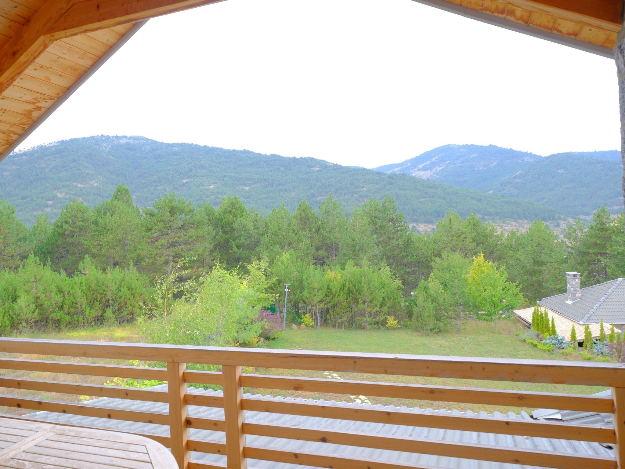 A wooden deck with a view of a mountainous landscape.