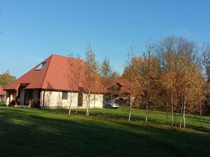 A house with a red roof, a small porch, and a car parked in front. - Fuchsbau in Waldnähe by Interhome (Kuldiga)