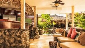 A tropical-themed lounge area with a stone wall, a bar, and outdoor seating. - "Casa Meloso" mit eigenem Pool by Interhome (Huacas)