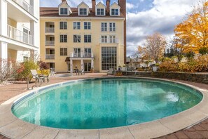 Ein Poolbereich mit einem Gebäude im Hintergrund.