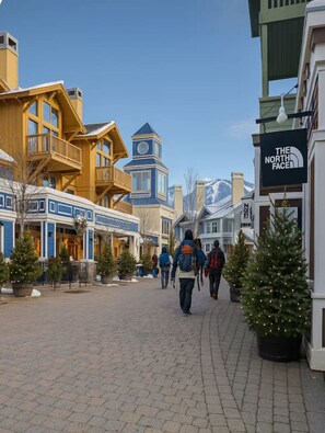 Une rue piétonne bordée d’immeubles, dont un hôtel qui affiche une enseigne avec l’inscription « The North Face ».