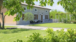 A stone house with a tiled roof, a paved driveway, and a well-maintained lawn. - Villa Balarini (Istria - Labin) (Šumber)