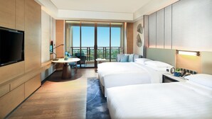 A hotel room with two beds, a TV, a balcony with a view, and a small table with chairs. - Yongan Hotel (Sanming)