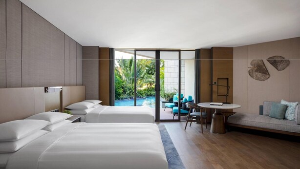 A modern hotel room with two beds, a balcony with a pool, and a seating area with a table and chairs. - Yongan Hotel (Sanming)